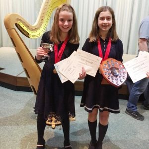 Photo of two young harp players holding their awards